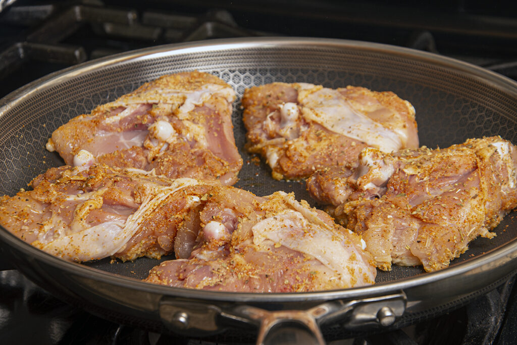 Pan frying the chicken, skin side down.