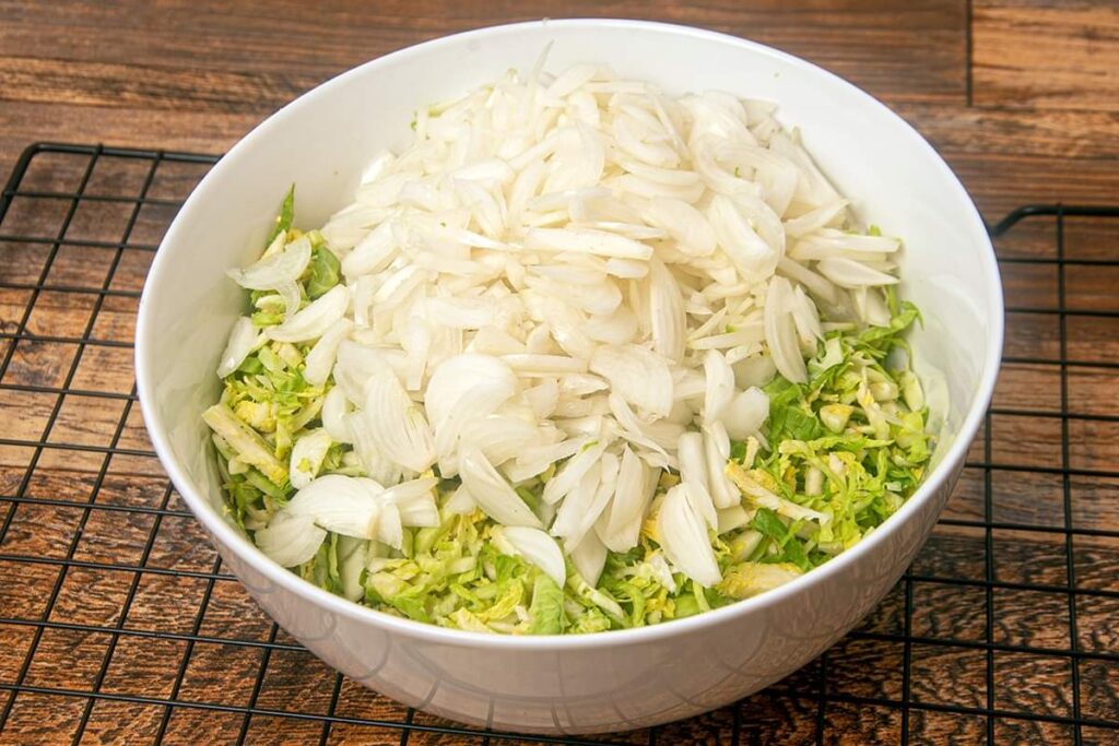 Shaved brussels sprouts and onions in a bowl