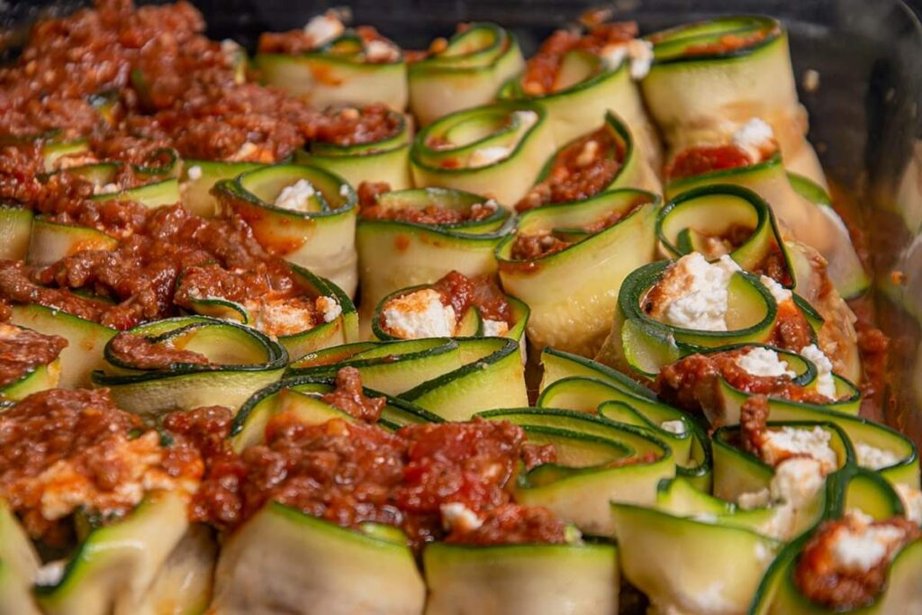 Place the roll ups into a baking pan and top with remaing meat, shredded parmesan and mozzarella cheese.